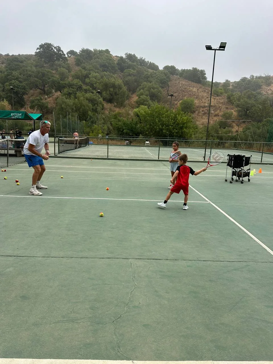 Rhino coach teaching children during a junior tennis session in Estepona