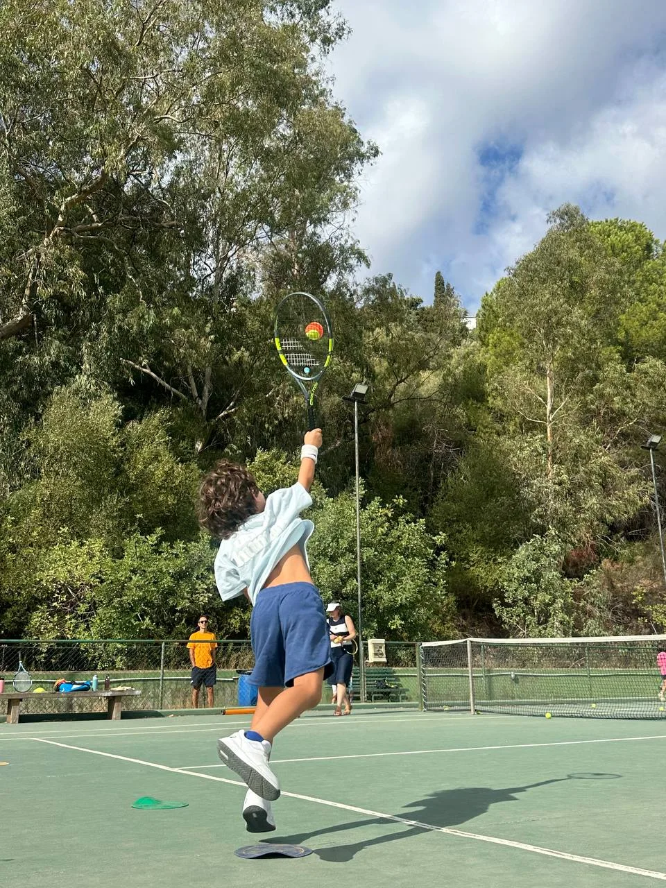 Tennis player working on a serve at the academy